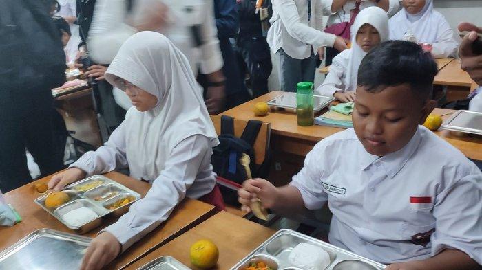 Siswa SD Susukan 01 ketika membuka makan bergizi gratis di SDN 01 Susukan, Ciracas, Jakarta Timur.