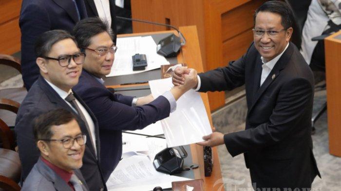 REVISI UU TNI - Menteri Hukum Supratman Andi Agtas berjabat tangan dengan Ketua Komisi I DPR RI Utut Adianto saat rapat persetujuan tingkat I RUU TNI di Kompleks Parlemen, Senayan, Jakarta, Selasa (18/3/2025). Komisi I DPR menyetujui pembahasan Rancangan Undang-Undang (RUU) tentang Perubahan atas Undang-Undang Nomor 34 Tahun 2004 tentang Tentara Nasional Indonesia (TNI) pada tingkat I, untuk dibawa ke tingkat selanjutnya di Rapat Paripurna DPR. (TRIBUNNEWS/IRWAN RISMAWAN)