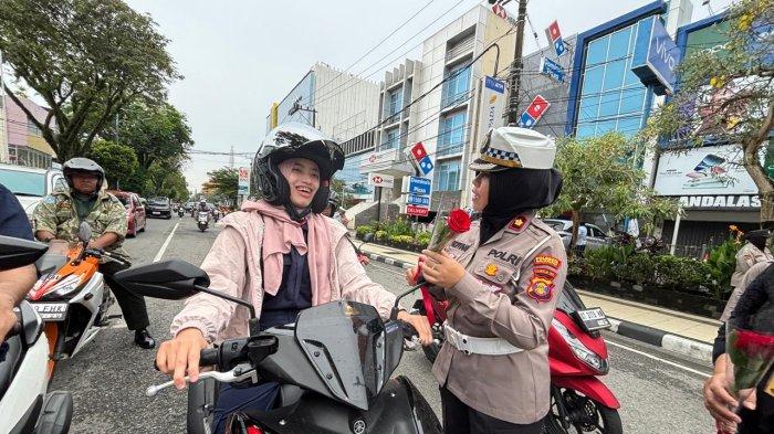 HARI KARTINI 2025 - Hujan gerimis yang membasahi Kota Balikpapan pada Senin (21/4/2025) pagi tidak menyurutkan semangat para polwan dari Polresta Balikpapan. Mengenakan kebaya warna-warni yang anggun, mereka berdiri sigap di bawah lampu lalu-lintas simpang Plaza Balikpapan, membagikan bunga mawar merah kepada para pengendara, khususnya kaum perempuan. (TRIBUNKALTIM.CO/DWI ARDIANTO)