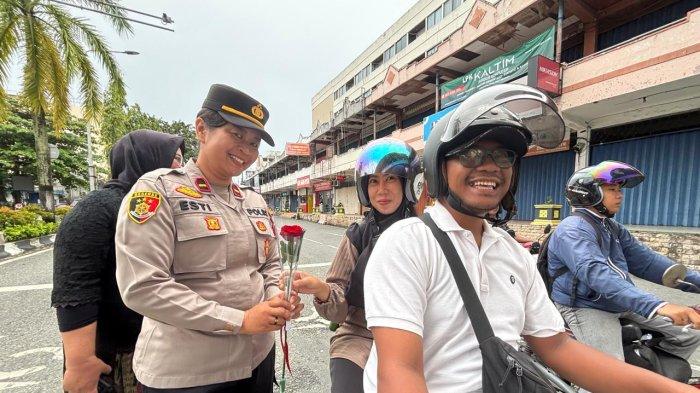 HARI KARTINI 2025 - Hujan gerimis yang membasahi Kota Balikpapan pada Senin (21/4/2025) pagi tidak menyurutkan semangat para polwan dari Polresta Balikpapan. Mengenakan kebaya warna-warni yang anggun, mereka berdiri sigap di bawah lampu lalu-lintas simpang Plaza Balikpapan, membagikan bunga mawar merah kepada para pengendara, khususnya kaum perempuan. (TRIBUNKALTIM.CO/DWI ARDIANTO)