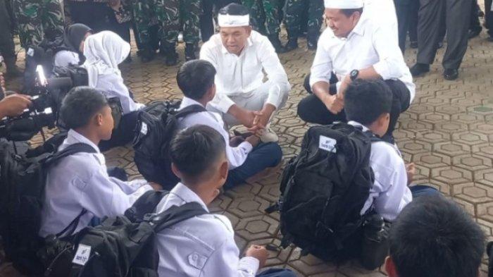 BARAK MILITER - Gubernur Jawa Barat Dedi Mulyadi sedang bercakap dengan siswa asal Sumedang yang lebih suka ngurus kuda dari pada sekolah di Barak Militer Markas Kodim 0610/Sumedang, Jumat (9/5/2025). Menyoroti aksi premanisme yang meresahkan, pengamat politik Rocky Gerung sentil program Dedi Mulyadi, lebih preman yang dibawa ke barak militer bukan anak nakal. (KOMPAS.COM/AAM AMINULLAH)