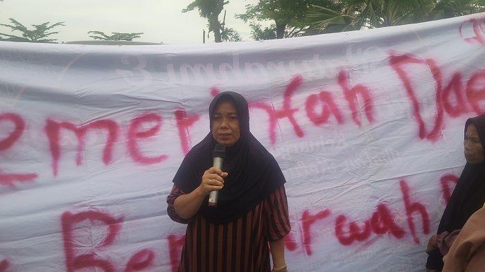 DEMO KORBAN LONGSOR - Wati, salah satu warga korban longsor di Desa Batuah, Kutai Kartanegara, mengungkapkan jeritan hatinya dalam aksi demonstrasi yang digelar di depan Kantor Gubernur Kalimantan Timur, Senin (2/6/2025). (TRIBUNKALTIM.CO/GREGORIUS AGUNG)