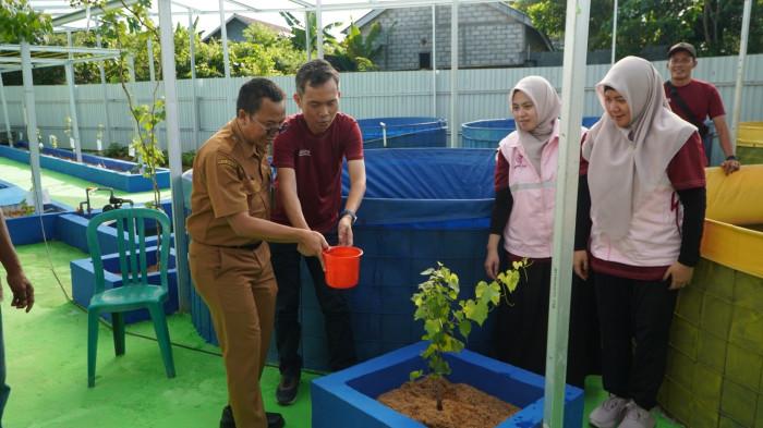 Manager PLN UP2B Kalselteng, Indrayadi, bersama perwakilan Pemerintah Kelurahan Cempaka melakukan penyiraman bibit anggur secara simbolis sebagai bagian dari peluncuran program Integrated Farming Pokmas Cempaka Sari.
