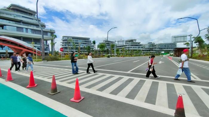 IKN DI KALTIM - Masyarakat berkunjung ke bagian dalam kawasan IKN Nusantara di Kaltim, dari satu gedung ke gedung lain harus berjalan kaki, tidak tersedia angkutan kendaraan bermotor, 5 Juli 2025. Mereka yang berjalan kaki bisa rasakan manfaat dari sisi kebugaran tubuh.