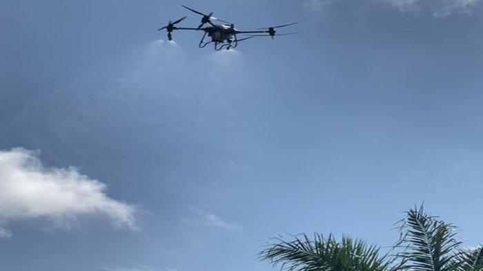 Menggunakan drone DSN Group melakukan penyemprotan kebun sawit warga mencegah berkembangnya hama ulat api