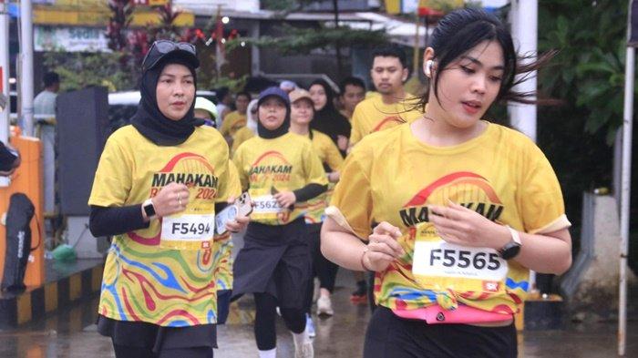 Peserta Mahakam Run melintasi Jalan Slamet Riyadi Samarinda, Minggu (25/8/2024). Hujan yang mengguyur tak mematahkan semangat para pencinta lari ini.