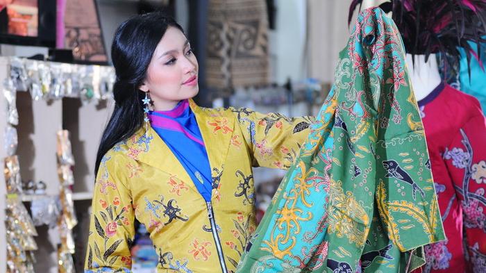 Novita Adipati Chandra mengenakan pakaian Batik saat memegang kain Batik hasil kerajinan khas Kalimantan di Batik Rumah Ampiek, Balikpapan, Kalimantan Timur pada Sabtu 23 Januari.
