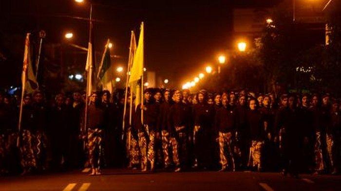 Warga berjalan kaki dalam keheningan mengelilingi kompleks Keraton Yogyakarta, Yogyakarta, saat mengikuti tradisi Tapa Bisu Lampah Mubeng Beteng, Selasa (4/11/2013) dini hari. Tradisi yang dilangsungkan setiap pergantian tahun baru hijriah ini dilakukan sebagai sarana perenungan dan instropeksi warga atas berbagai hal yang telah dilakukan pada tahun sebelumnya.