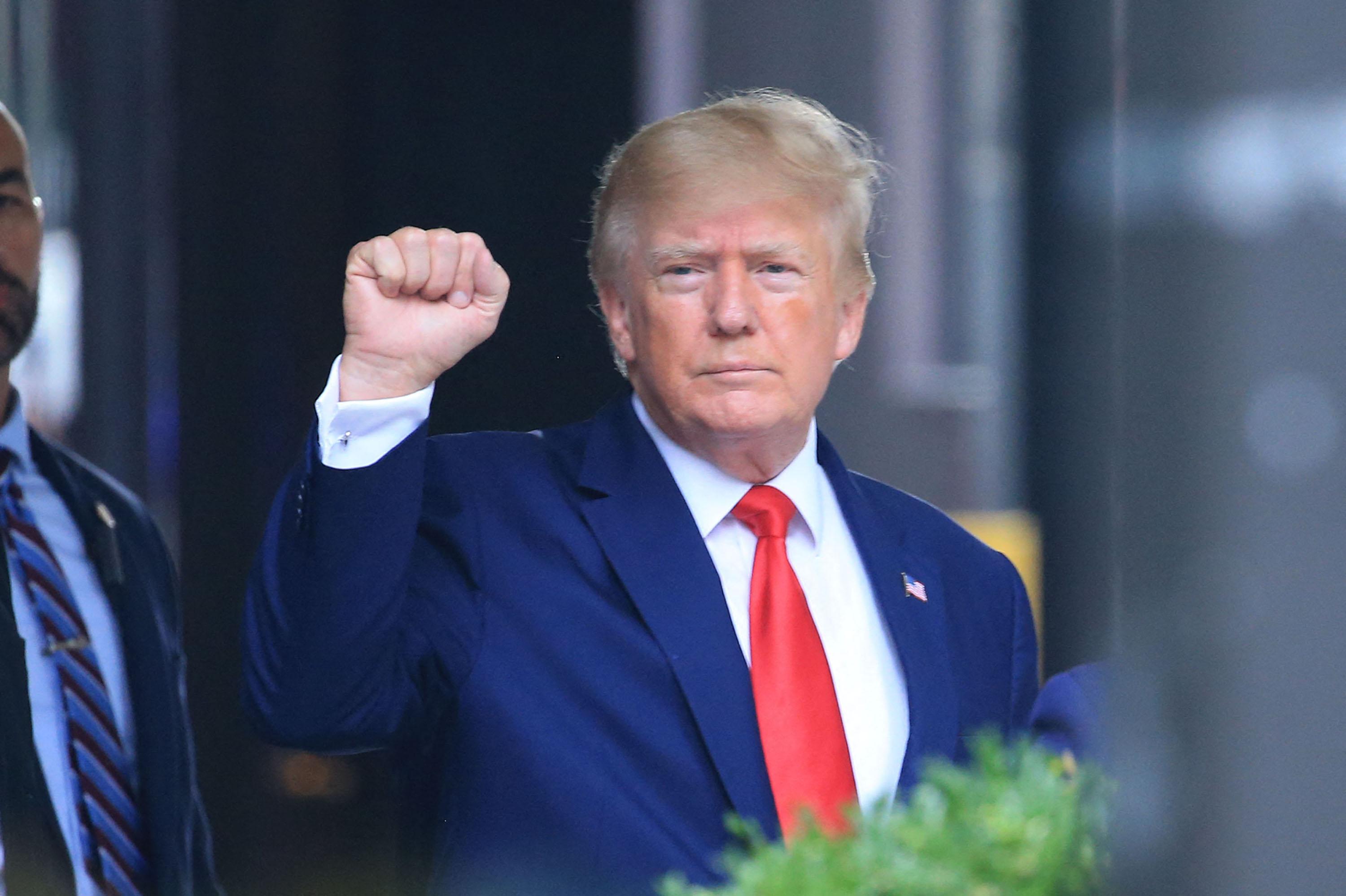 ACUNGKAN TINJU - Donald Trump mengacungkan tinjunya saat berjalan ke sebuah kendaraan di luar Trump Tower di New York City pada 10 Agustus 2022.