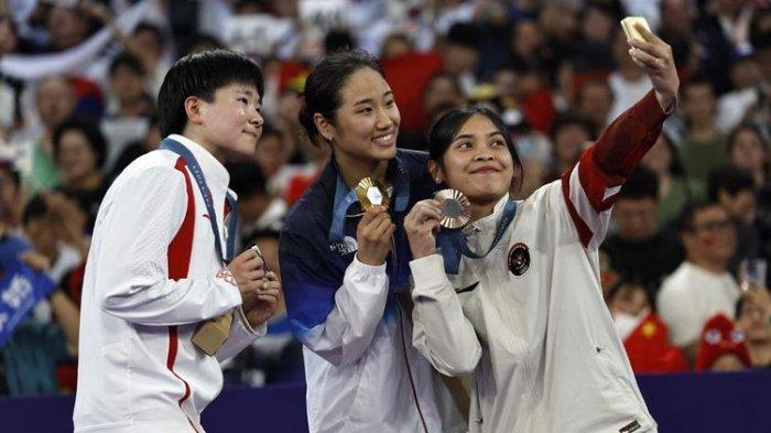 Gregoria Mariska Tunjung (kanan) berpose bersama An Se-young dan He Bing Jiao usai prosesi pengalungan medali bulu tangkis tunggal putri Olimpiade Paris 2024 di Arena Porte de la Chapelle, Paris, Prancis, Senin 5 Agustus 2024.
