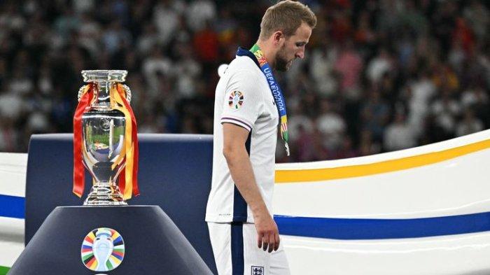 Penyerang Inggris, Harry Kane berjalan melewati trofi setelah menerima medali perak pada akhir pertandingan final UEFA Euro 2024 antara Spanyol vs Inggris di Olympiastadion di Berlin pada 14 Juli 2024. Spanyol menang 2-1.