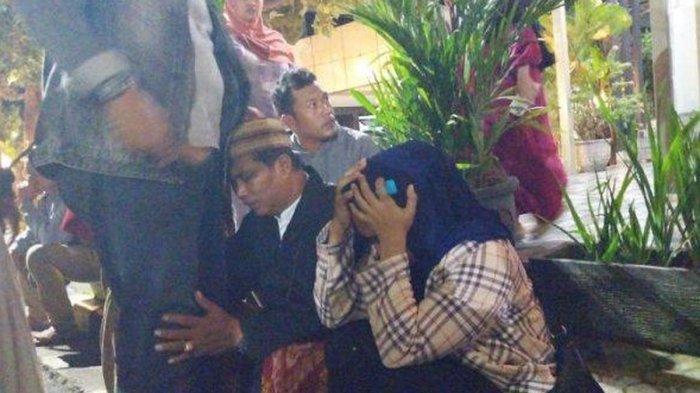Seorang pria dan wanita menangis saat duduk di trotoar area Pelabuhan Ketapang, Kamis (3/7/2025) pagi. Keduanya diduga keluarga korban KMP Tunu Pratama Jaya tenggelam.
