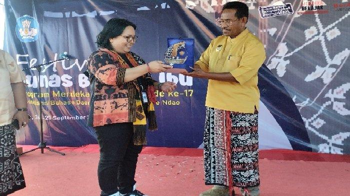 FESTIVAL - Kepala Kantor Bahasa NTT Elis Setiati menyerahkan plakat festival kepada Wakil Bupati Rote Ndao Stefanus Saek saat acara pembukaan di Stadion Paulina Haning-Bullu. Selasa, 26 September 2023.