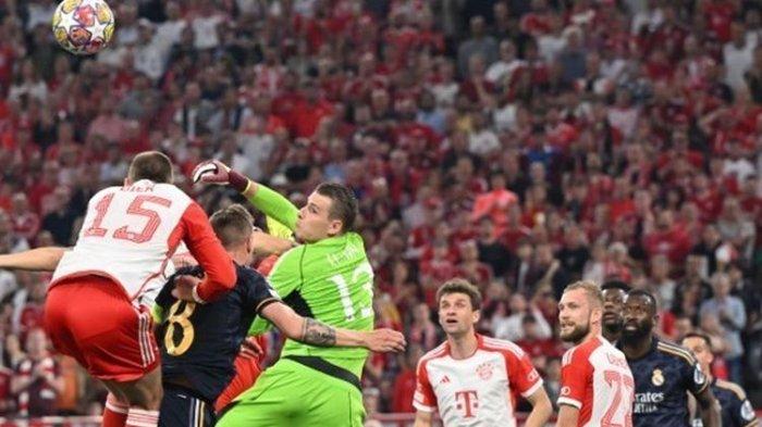 Kiper Real Madrid, Andriy Lunin (tengah) melompat untuk mengambil bola dalam laga leg pertama semifinal Liga Champions 2023-2024 antara Bayern vs Madrid di Stadion Allianz Arena pada 30 April 2024. Hasil akhir imbang 2-2.