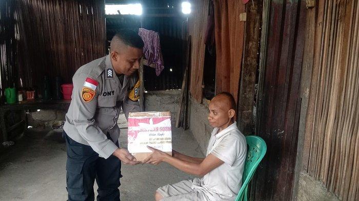 LETMAFO TIMUR - Bhabinkamtibmas Desa Letmafo Timur, Brigpol Antonius T. Bosko, S. Ip saat menyerahkan kado menjelang HUT Bhayangkara kepada penyandang disabilitas di Desa Letmafo Timur, Jumat, 27 Juni 2025.