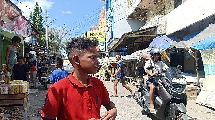 SOSOK API LINOME- Sosok bocah Api Linome (12) saat mengamati para pengunjung pasar yang selesai belanja untuk menawarkan jasa angkat barang di Pasar Inpres Naikoten, Kota Kupang.