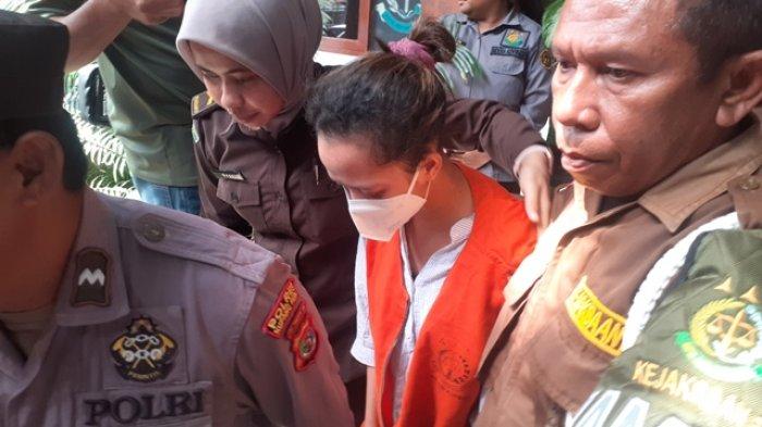 KAWAL TERSANGKA - Tersangka Fani dikawal ketat oleh petugas saat digiring ke mobil tahanan untuk dibawa ke Lapas Perempuan Kupang, Kamis (12/6/2025).