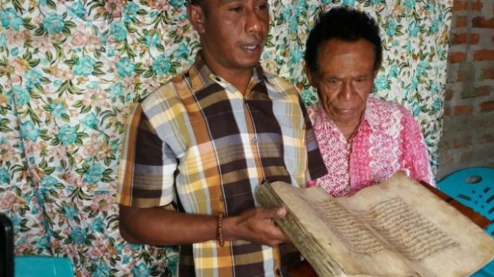 Nurdin Gogo (kiri) bersama kerabatnya, sedang menunjukkan Al Quran tua dari kulit kayu, Rabu (10/8/2016).