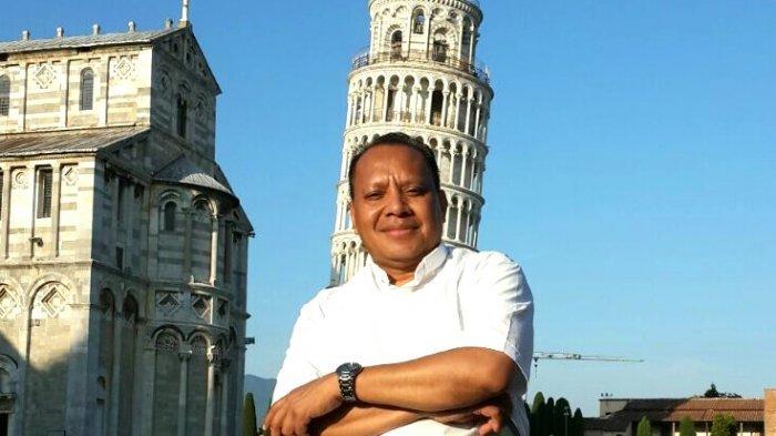RD Maxi Un Bria dengan latar belakang menara Pizza Italia.