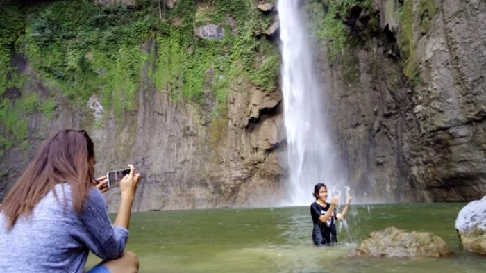 Pengunjung saat mandi di Air Terjun Ngabatata di desa Rendubutowe Kecamatan Aesesa Selatan, Kabupaten Nagekeo, Minggu (24/6/2018).