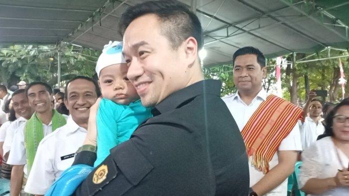 GENDONG – Wali Kota Kupang, dr. Christian Widodo menggendong Novlano Jason Samuel Umbu Rey. Orangtua Novlano sangat bahagia.