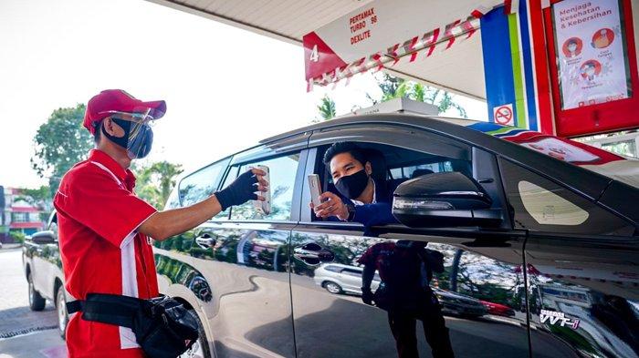 LAYANAN - Seorang pemudik arus balik yang membeli BBM di SPBU Pertamina menggunakan transaksi non tunai.