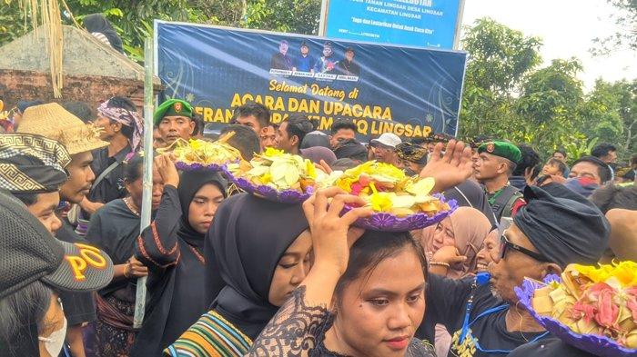 Warga membawa topat sebagai senjata saat Perang Topat di Pura Kemalik, Lingsar Kabupaten Lombok Barat, Senin (27/11/2023).