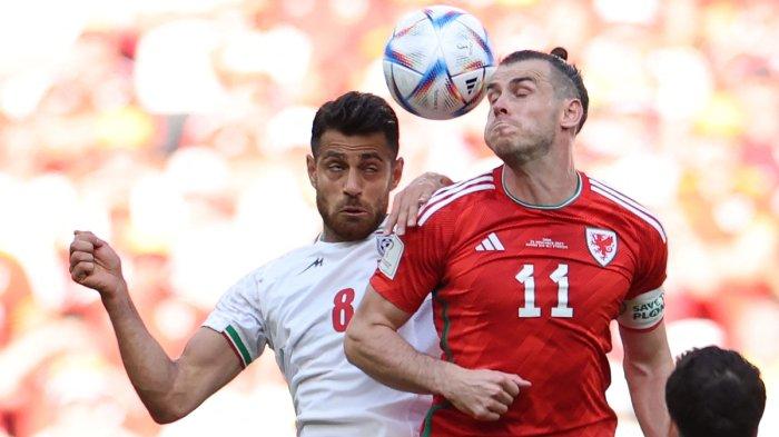 Bek Timnas Iran, #08 Morteza Pouraliganji (kiri) berebut bola atas dengan penyerang Timnas Wales, #11 Gareth Bale dalam laga sepak bola Grup B Piala Dunia 2022 Qatar antara Wales melawan Iran di Stadion Ahmad Bin Ali, di Al-Rayyan, sebelah barat Doha, Qatar, Jumat (25/11/2022) waktu setempat. AFP/FADEL SENNA