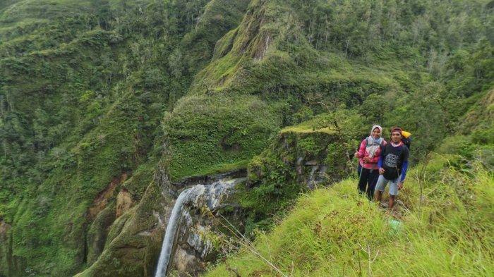 AIR TERJUN: Ahmad Viki, salah seorang pendaki Gunung Rinjani (kanan) berfoto dengan latar Air Terjun Penimbungan di jalur Torean.
