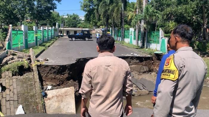 JALAN TERPUTUS - Warga melihat kondisi jalan masuk BTN Mahkota Bertais Lingkungan Pengempel Indah, Kelurahan Bertais, Kota Mataram putus akibat banjir, Senin (7/7/2025).