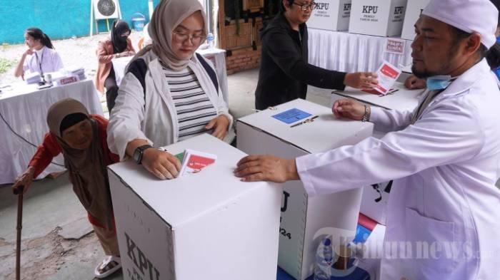Petugas Kelompok Penyelenggara Pemungutan Suara (KPPS) mengenakan pakaian tenaga medis dalam Pemilihan Umum (Pemilu) 2024 di Tempat Pemungutan Suara (TPS) 64, Kelurahan Cikutra, Kecamatan Cibeunying Kidul, Kota Bandung, Jawa Barat, Rabu (14/2/2024).