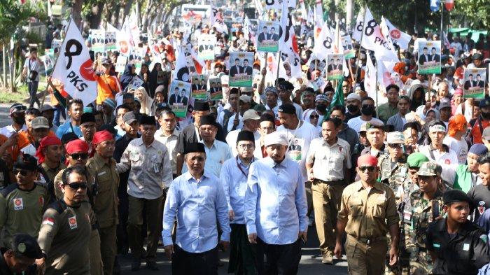 Bakal pasangan calon (Bapaslon) bupati dan wakil bupati Suryadi Jaya Purnama (SJP) dan TGH Lalu Gede Khairul Fatihin berjalan diiringi Ketua Umum (Ketum) Pengurus Besar Nahdlatul Wathan (PBNW) TGKH Muhammad Zainuddin Atsani dan pendukung saat mendaftar di KPU Lombok Timur untuk maju di Pilkada 2024, Kamis (29/8/2024).