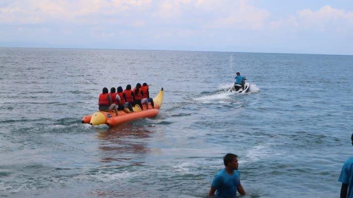 Wisatawan yang bermain wahana watersport di pantai Senggigi