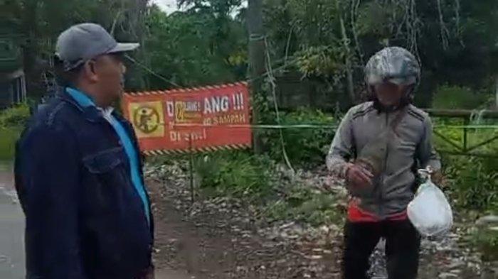 SAMPAH TAK BERUJUNG : Seorang warga diminta memungut kembali bungkusan plastik warna putih berisikan sampah yang dibuang di kawasan sisi barat pintu masuk akses Suramadu, Kampung Tangkel, Desa/Kecamatan Burneh. Buruknya pengelolaan sampah oleh Dinas Lingkungan Hidup Bangkalan dalam 6 tahun terakhir, masih terus menggelinding dan semakin membesar bak bola salju