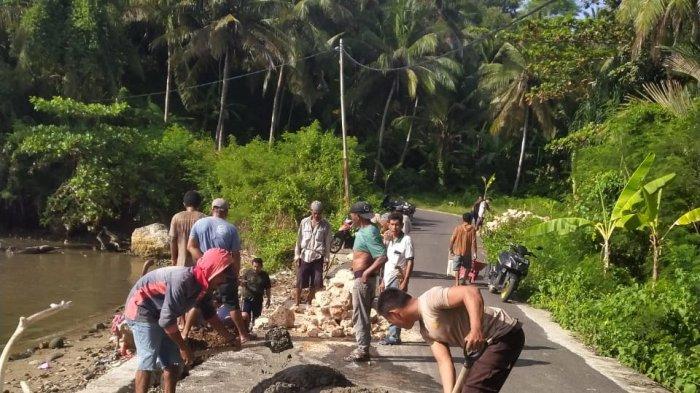 ABRASI - Warga bersama Bhabinkamtibmas Herlang, Bripka Jumliadi, memperbaiki tanggul jalan rusak akibat abrasi gelombang laut di Tanuntung, Bulukumba, Sabtu (26/4/2025)