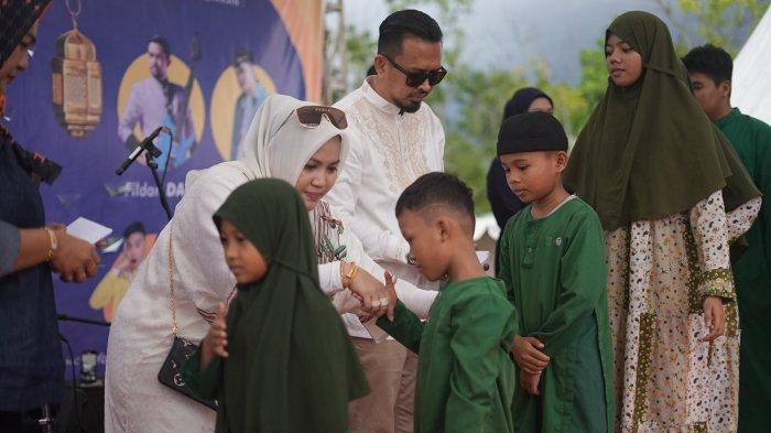 Pengusaha muda asal Palopo Putri Dakka bagi-bagi sembako di lapangan Gaspa Palopo, Kamis (13/04/2023). Warga datang dari beberapa wilayah di Palopo untuk mendapat paket sembako gratis.