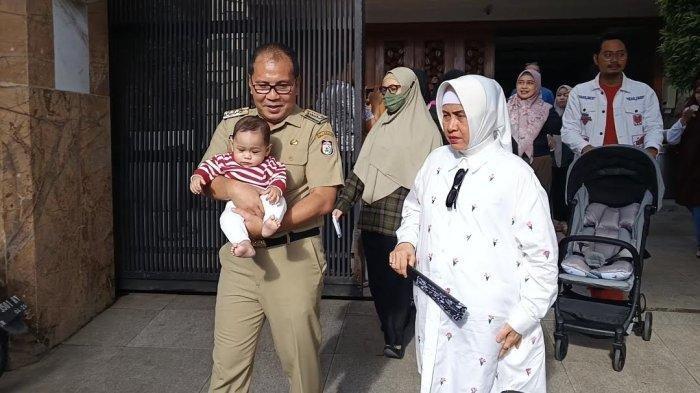 Wali Kota Makassar Danny Pomanto saat menuju TPS 001 Kelurahan Maricaya Selayan, Mamajang, Kota Makassar, Rabu (14/2/2024). Danny menggendong cucu menuju TPS yang tak jauh dari kediamannya.