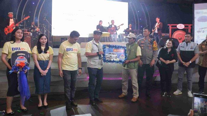 Pimpinan Cabang BRI Panakkukang, Asep Suhendra (empat dari kanan) menyerahkan secara simbolis hadiah utama pengundian Panen Hadiah Simpedes (PHS) kepada perwakilan pemenang yang berlangsung di D’liquid Hotel Claro, Makassar, Sabtu (12/10/2024). Nasabah dari Unit Antang Panakkukang, Rahman keluar sebagai pemenang PHS yang mendapatkan mobil Suzuki KI XL 7 Zeta.