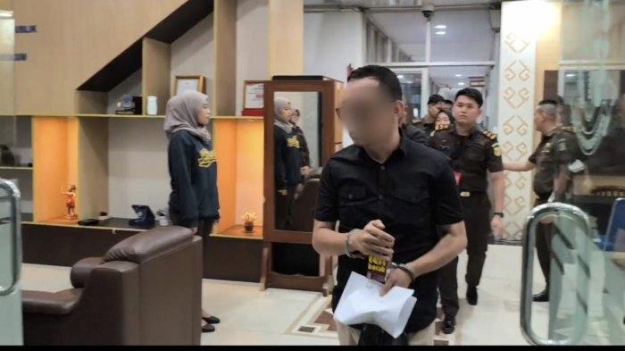DITAHAN - Kejaksaan Negeri (Kejari) Manado, resmi menahan AT oknum pengacara tersangka kasus dugaan rudapaksa terhadap seorang perempuan berinisial LI (39). AT dengan tangan terborgol digiring ke mobil tahanan Kejari Manado, Selasa (27/5/2025) malam.