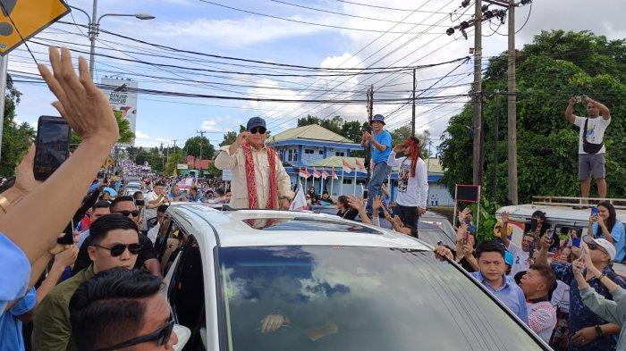 Dari dalam kendaraan, Prabowo Subianto menyapa para pendukungnya sepanjang perjalanan di Manado, Sulawesi Utara.