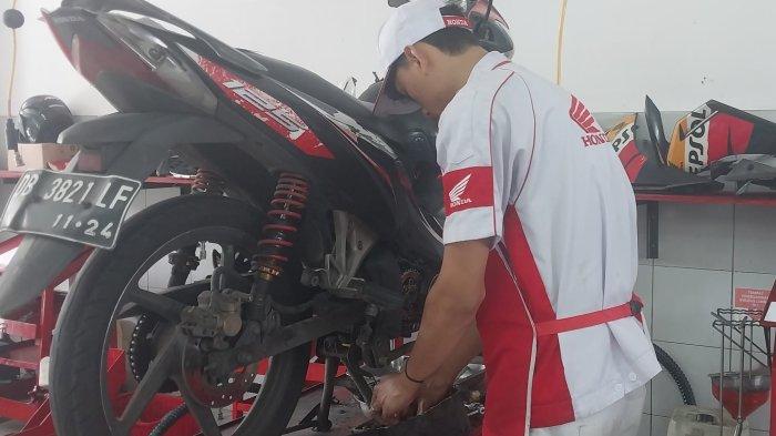 MOTOR HONDA - Pegawai DAW sedang menyervis motor. Setiap konsumen motor Honda akan mendapatkan fasilitas kupon servis berkala gratis sesuai buku panduan yang ada.