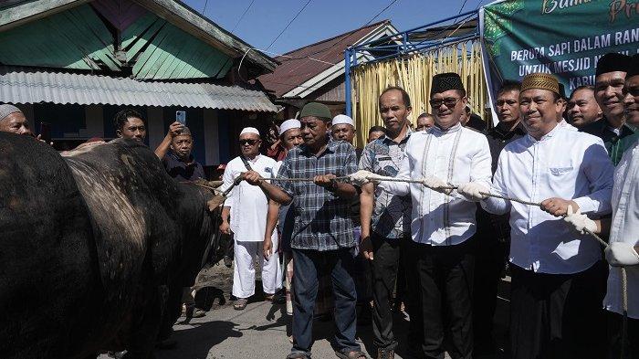 SERAHKAN - Gatot kaca sapi Presiden Prabowo untuk jamaah Nurul Bilad Likupang 2, Minahasa Utara (Sulut), Tampak Bupati Minut Joune Ganda langsung memberikan sapi tersebut kepada jamaah masjid.
