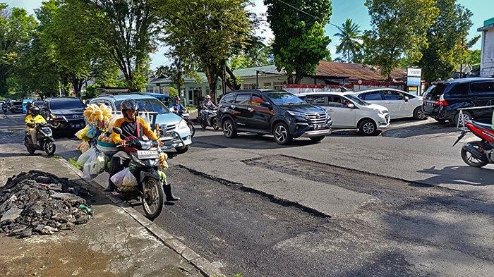 Kendaraan berjalan lambat akibat galian tambal sulam aspal di Jalan A Yani Sario, Manado, Senin (9/12/2024).