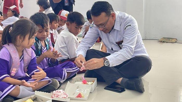 Kepala Pelabuhan Perikanan Samudera (PPS) Aertembaga di Bitung Sulut memberikan makan siang bergizi dan susu ikan serta ikan makan di tengah-tengah ratusan anak dari SD GMIM 11 Aertembaga, Selasa (29/10/2024)