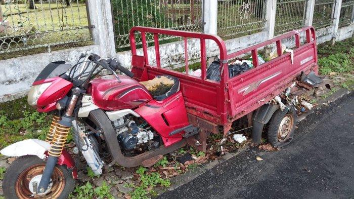 Motor pengangkut sampah sudah terparkir cukup lama, dengan kondisi ban belakang yang pecah, serta tempat muatannya yang sudah rusak