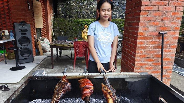 BABI GULING - Ni Nyoman Bella saat mengolah menu Babi Lapis Guling di Jalan Parigi Tujuh Kecamatan Malalayang Satu, Perumahan Dolog, Kota Manado, Sulawesi Utara.