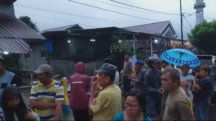ORANG HANYUT: Warga berkerumun di dekat Sungai di Kelurahan Kotobangon, Kotamobagu yang menjadi lokasi korban hanyut di Kotamobagu, Kamis (30/1/2025). Hingga saat ini korban belum ditemukan.