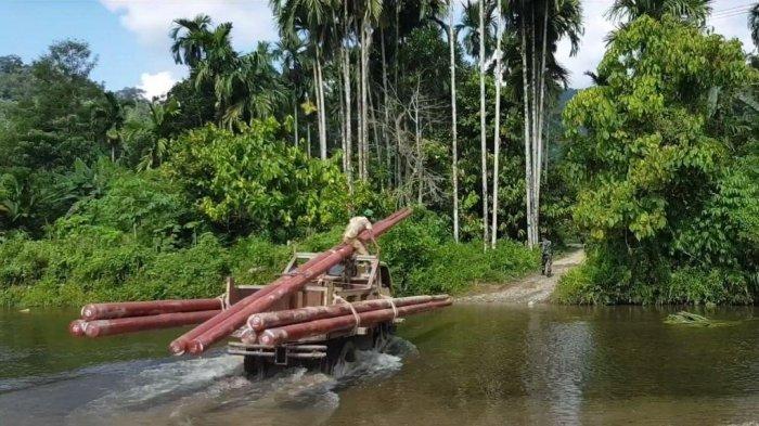 Petugas PLN membawa material pendukung kelistrikan menembus sungai ke Desa Gunung Menasaha, Kecamatan Setia Bakti, Kabupaten Aceh Jaya, Provinsi Aceh yang jaraknya kurang lebih 200 kilometer dari Banda Aceh.