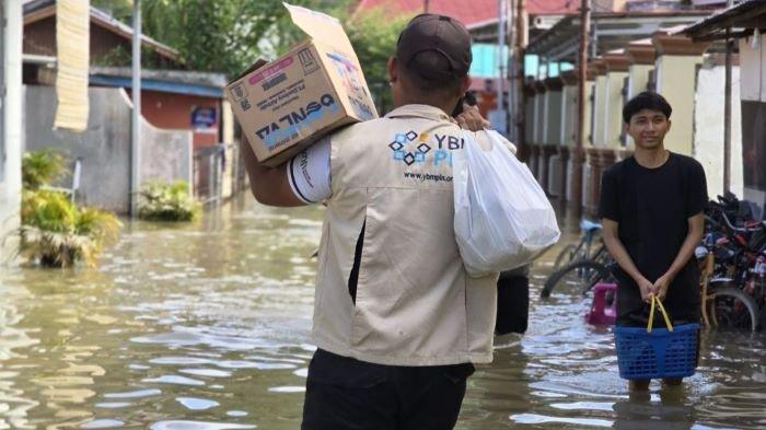 Relawan Yayasan Baitul Maal PLN (YBM PLN) PLN Unit Induk Distribusi Sulawesi Utara, Tengah, dan Gorontalo (UID Suluttenggo) menerjang lokasi terdampak banjir untuk menyalurkan bantuan kapada masyarakat yang terdampak
