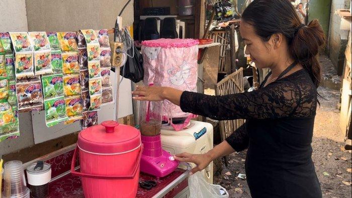 Siti Aminah, warga Kelurahan Pengasinan, Kecamatan Rawalumbu, Bekasi, Jawa Barat, tampak menyiapkan minuman yang Ia jual di depan rumahnya. Setelah menerima bantuan sambung listrik gratis dari program Light Up The Dream, kini dirinya tidak perlu lagi menyambung listrik dari tetangga dan semakin bersemangat untuk berjualan serta beraktivitas bersama keluarga di rumahnya.